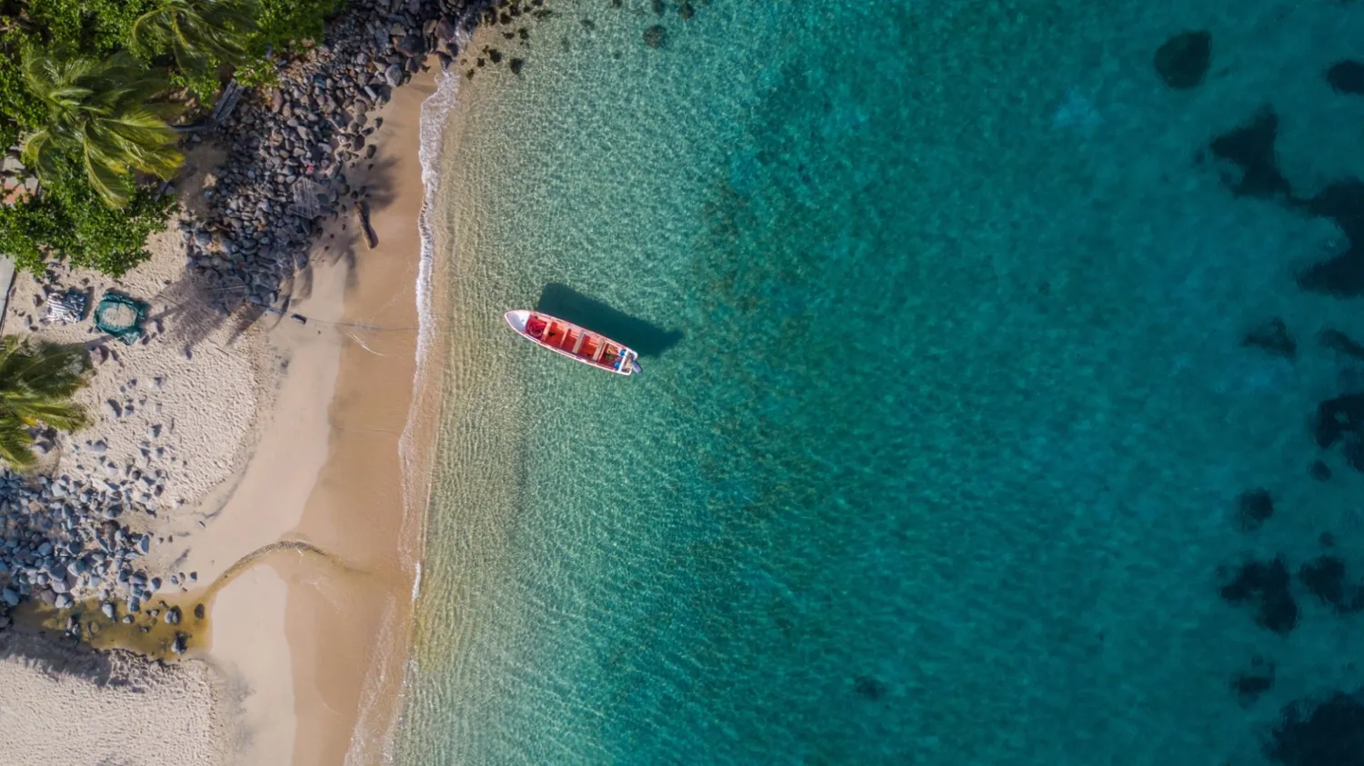 Plajă secretă din Martinica cu barcă de pescuit roșie și ocean turcoaz – Caraibe