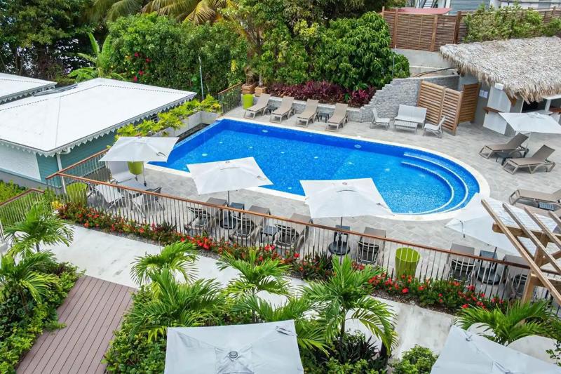 Vedere aeriană a piscinei exterioare cu șezlonguri și grădină tropicală – Hotel Diamant les Bains, Martinica